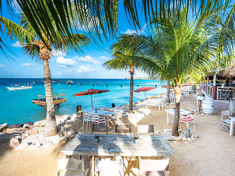 A view of the beach bar and water sports center at Coral Estates in Curaçao, with blue Caribbean water in the background.