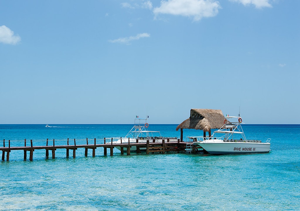 Boats from the Dive House fleet pick up at the Secrets pier. The dive staff handles all gear transfer and storage.