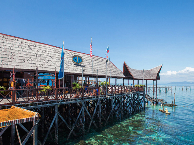 An over-water dive center provides easy access to boats and convenient shore diving via secure steps.