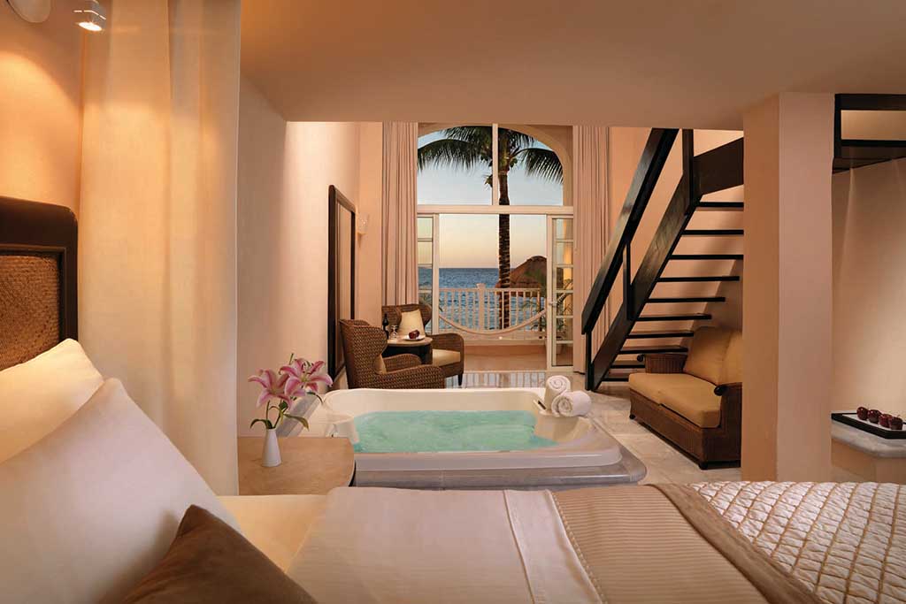 Rooms include a Jacuzzi-style soak tub set between the bed and sitting areas.