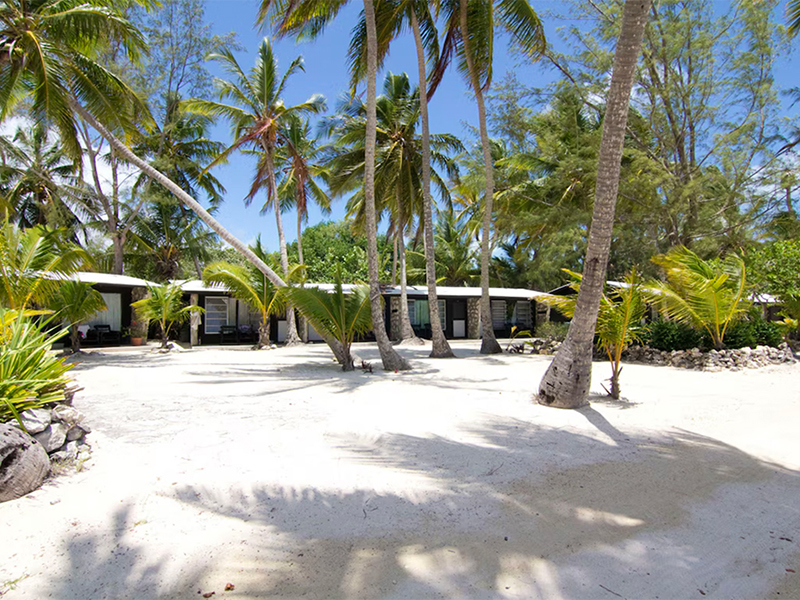 Cottages at Small hope Bay face a white sand beach.