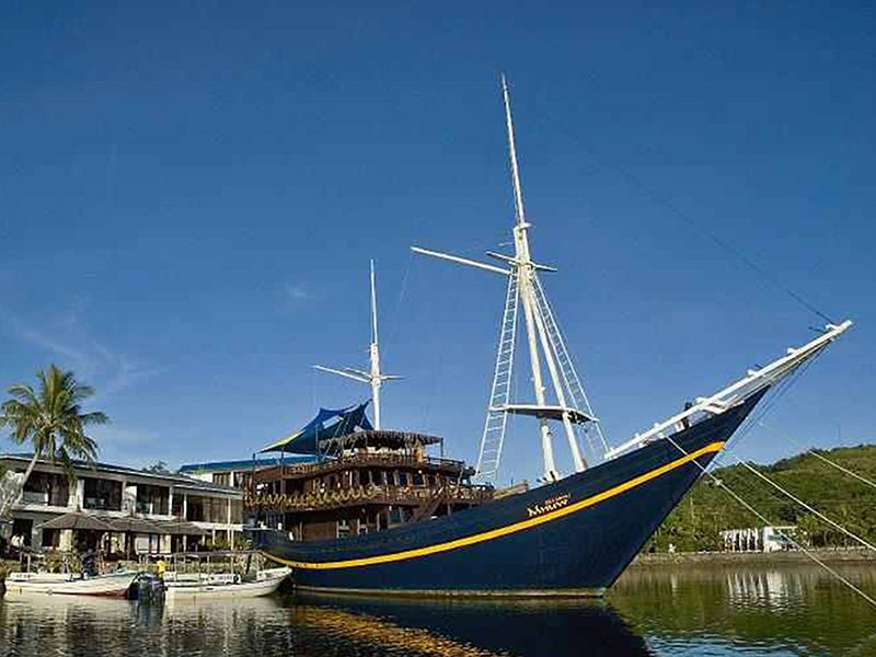 The Mnuw is a historic South Seas schooner owned by Manta Ray Bay Resort, now serving as a floating restaurant and bar.